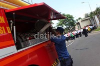 Seorang petugas menyiapkan selang yang akan digunakan untuk memadamkan api dalam simulasi penanganan bencana di Gedung PHE, Jakarta.