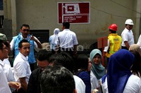 Para karyawan dievakuasi keluar gedung.