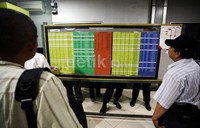     Beberapa penumpang melihat jadwal keberangkatan KRL.