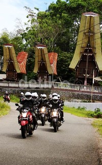 Para peserta touring melintas di depan rumah khas Tana Toraja.