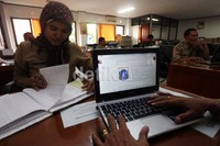 Pegawai Negeri Sipil melihat pengumuman lelang lurah dan camat melalui situs Badan Kepegawaian Daerah DKI di Kelurahan Kenari, Jakarta Pusat, Rabu (3/4/2013).