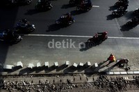 Sejumlah kendaraan melintas di samping pengerjaan proyek trotoar.