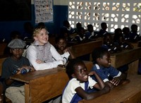 Madonna tersenyum manis di dalam kelas ditemani kedua anak angkatnya, David Banda dan Mercy James. AFP/Amos Gumulira.