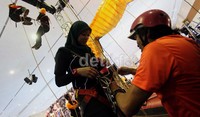 Seorang pengunjung mencoba panjat tebing yang disediakan di salah satu stand.