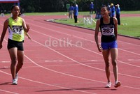 Pelari Jawa Timur, Eka Cahya (kanan), tersenyum setelah ia berhasil melalui rintangan di Babak 1 Remaja Putri Lari 200 meter.