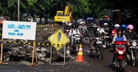 Karena sebagian jalan tengah diperbaiki, para pengendara pun terpaksa berjalan lambat.
