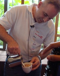 Gibbons sedang membuat latte art pada cappuccino hangat dengan teknik free pouring.