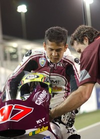 Rafid Topan menjelang balapan, Minggu (7/4), mendengarkan arahan kru timnya, QMMF Racing Team.