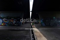 Seorang warga melintas di depan mural di flyover Slipi. Selain meminta pengecatan, Jokowi juga akan meminta tambahan tanaman. Salah satunya di median jalan tol, sehingga jalan bisa lebih hijau. mbudhy/Detikcom.