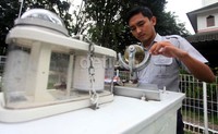 Petugas BMKG melihat alat pengukur curah hujan di Kantor BMKG, Kemayoran, Jakarta, Rabu (10/4).