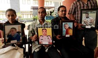 Mereka juga membawa foto-foto korban semasa hidup.
