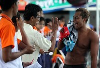 Gaya Siman (kanan) saat bercanda dengan para petugas, usai menyelesaikan nomor 100 meter gaya punggung putra.