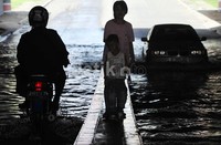 Para pengendara baik motor maupun mobil nekat menerobos genangan di underpass Kemayoran, Jakarta.