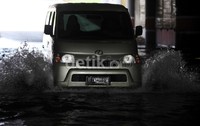 Sebuah mobil nekat menerobos genangan.