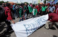 Sebagai bentuk penolakan, mereka membawa replika keranda mayat bertuliskan 'RUU Ormas'.
