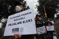 Dalam akisnya, mereka membawa poster, salah satunya bertuliskan Dilarang parkir kecuali pejalan kaki