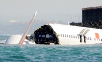 Ekor pesawat yang terpotong dari badan mulai jatuh ke laut.