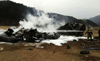 Petugas memadamkan api yang membakar heli Black Hawk. Belum diketahui penyebab pasti jatuhnya helikopter militer AS tersebut. Namun insiden ini terjadi saat berlangsung latihan militer gabungan AS-Korsel. Reuters/Yonhap.