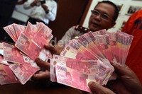Polisi memperlihatkan uang palsu pecahan seratus ribu rupiah saat jumpa pers di Polsek Jagakarsa, Jakarta, Selasa (16/4/2013).