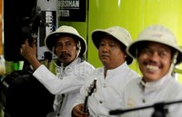 Dalam menghibur penumpang KA, mereka memakai pakaian serba putih.