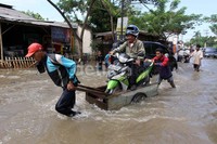 Banjir dimanfaatkan para pemilik gerobak untuk menawarkan jasa penyeberangan. Nizar Ramadika/detikFoto.