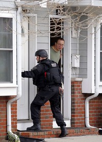 Tim SWAT juga menggeledah rumah warga. Dalam pengejaran tersebut, polisi juga mengandalkan informasi dari warga. Reuters/Jessica Rinaldi.