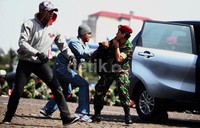 Digambarkan para perampok berusaha merampas tas milik anggota TNI.