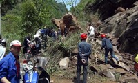 Petugas mengevakuasi korban gempa. Jalan-jalan tertutup longsor yang disebabkan gempa. REUTERS/Stringer.