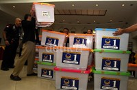 Petugas KPU menurunkan puluhan boks yang berisi berkas Caleg DPR dari atas mobil.
