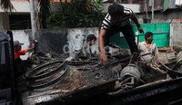 Warga mengambil barang-barang yang hangus terbakar dan mengangkutnya dengan mobil bak.
