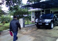 Para petugas masuk ke dalam rumah melalui pintu garasi.