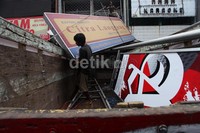 Papan reklame tersebut kemudian dibawa dengan truk.