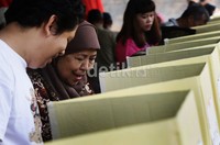 Seorang warga mencoblos dari bilik suara.