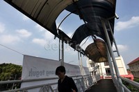 Pejalan kaki melintasi di JPO yang atapnya hampir roboh di kawasan Matraman, Jakarta Pusat.