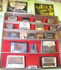Tak jauh dari bingkai mata uang kuno, terdapat rak yang berisi radio-radio kuno (Putri/detikTravel)