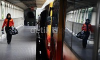 Seorang pekerja TransJakarta berjalan di samping bus-bus yang diparkir di Terminal Blok M, Jakarta.