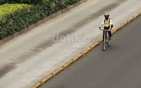 Bus TransJakarta dan kendaraan lainnya terhadang pendemo, pengendara sepeda ini pun melintas dengan lenggang.