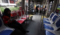 Seorang Pekerja TransJakarta jalur koridor 1 memilih bersantai dengan mambaca koran di dalam bus.
