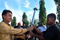 Menpora Roy Suryo menyerahkan obor kepada salah satu perwakilan warga.