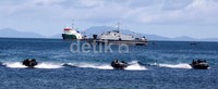 Pasukan amfibi Marinir turun dari kapal lalu meluncur menggunakan perahu karet. Aksi tersebut merupakan bagian dari simulasi penyerbuan musuh dari laut.