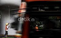 Dua orang pekerja melakukan pengecatan di jembatan layang Pancoran, Jakarta Selatan.     