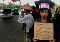 Massa dari kelompok buruh menggunakan kostum toga sarjana dan menuntut pencabutan Undang-undang Sistem Pendidikan Nasional Nomor 20 tahun 2003.