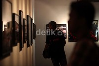 Seorang pengunjung serius memperhatikan salah satu foto.