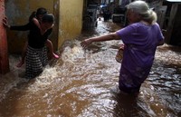 Warga yang sudah terbiasa dengan banjir tetap beraktivitas seperti biasa.