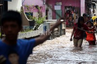 Petugas memasang tali agar warga yang melintas dapat berpegangan dan tidak terseret arus.