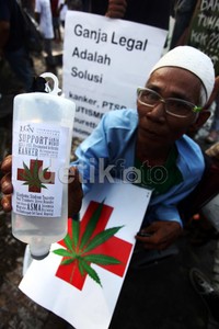 Pria tersebut membawa botol infus bergambar daun ganja.