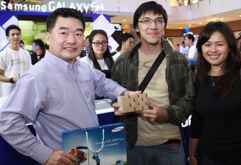 Yoo Young Kim, Managing Director SEIN (kiri) dan Vebbyna Kaunang, Marketing Director Mobile Phone, SEIN (kanan), pose dengan pembeli pertama Galaxy S4, Rodi, pengusaha asal Jakarta yang antri sejak pukul 5 pagi.     