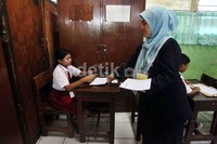 Guru membagikan soal ujian.