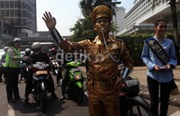 Untuk menarik simpati, 2 polisi berbusana seperti patung.