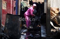 Beberapa warga mencari barang berharga di antara puing-puing kebakaran.